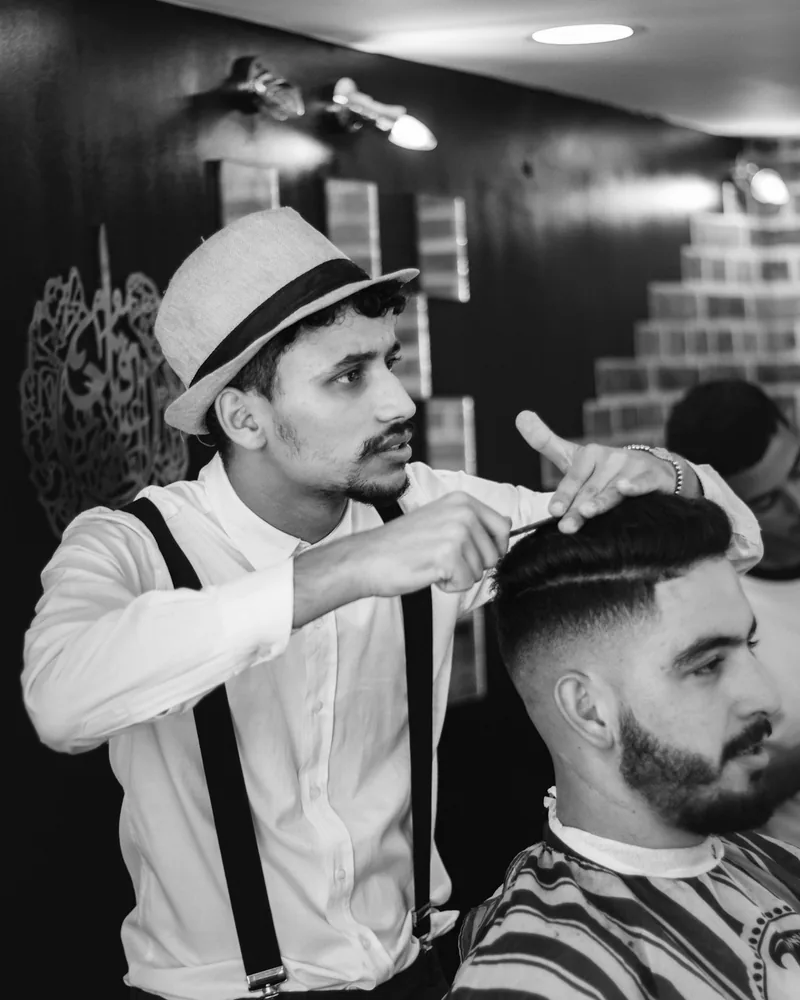 Diego cortando o cabelo de um cliente.